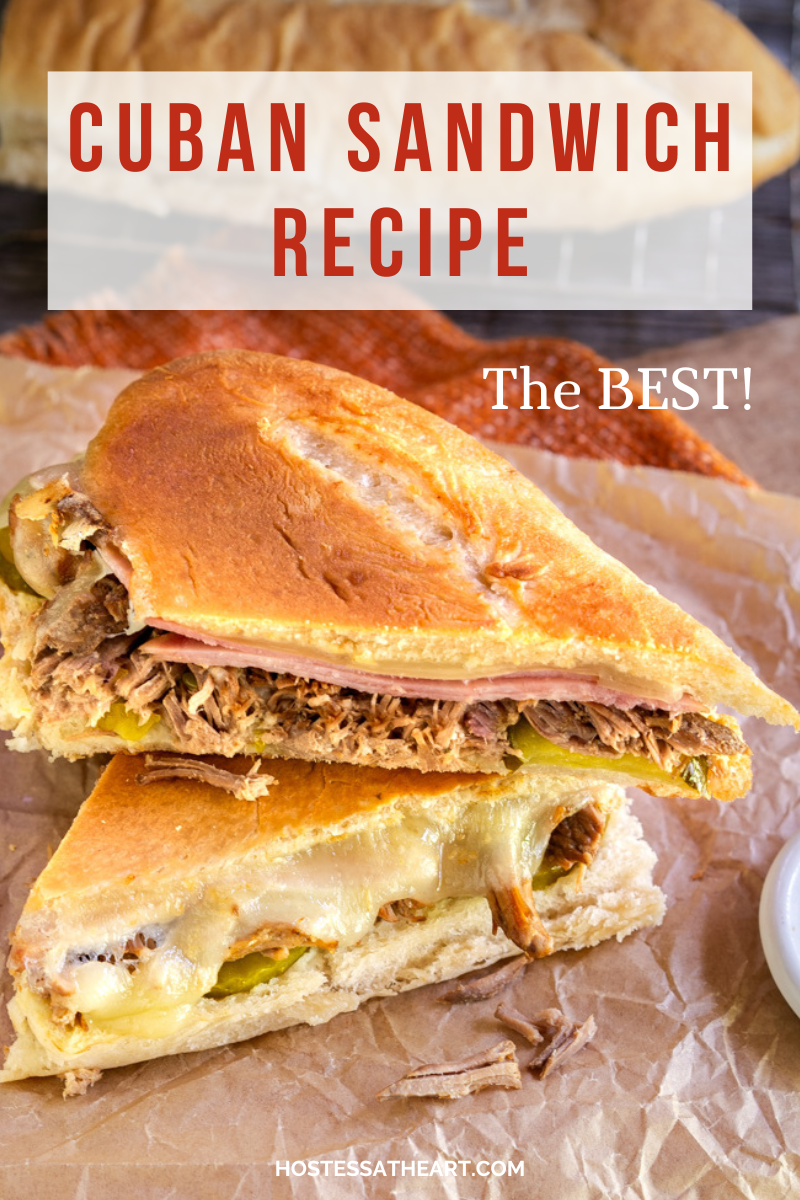 An authentic Cuban Sandwich pressed and sliced sandwich made of shredded pork, slices of ham, Swiss Cheese, pickles, and mustard -Hostess At Heart
