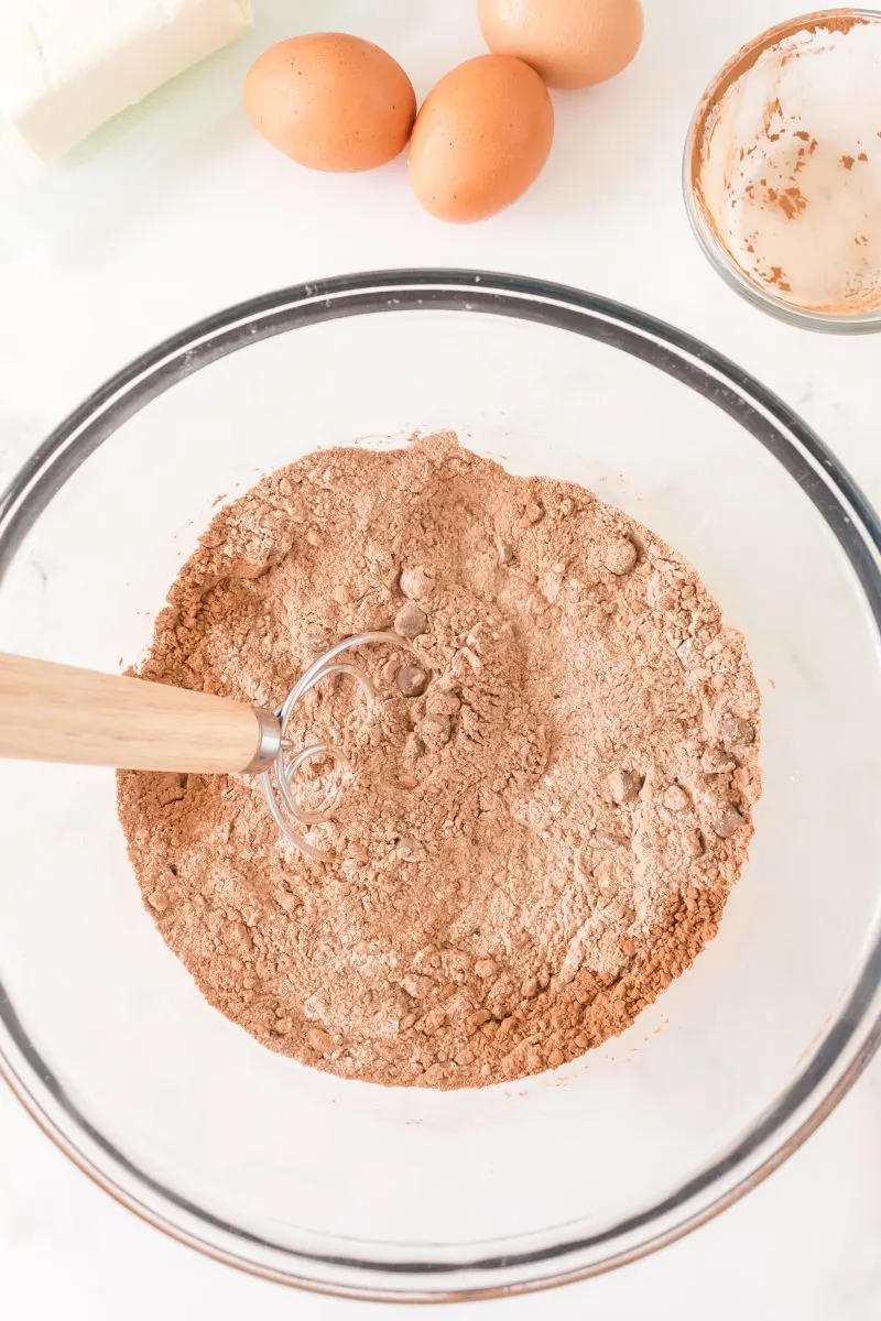 Sifted Chocolate and Flour mixed with chocolate chips in a mixing bowl - Hostess At Heart
