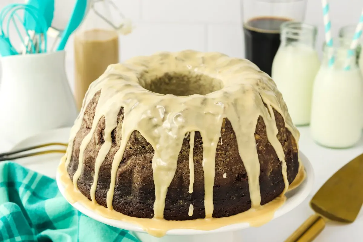 Sideview of a beautifully baked chocolate stout bundt cake drizzled with Irish cream glaze - Hostess At Heart