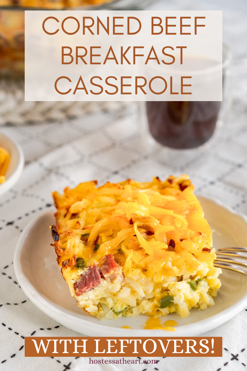 A sideview of a slice of egg casserole filled with corned beef, onion, green peppers, shredded potatoes and cheese. Hostess At Heart