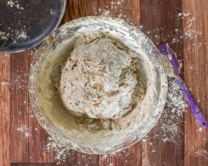 Bowl filled with craggy pumpernickel sourdough dough - Hostess At Heart