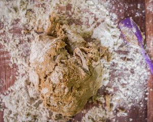 A ball of mixed pumpernickel dough sitting on a floured surface - Hostess At Heart