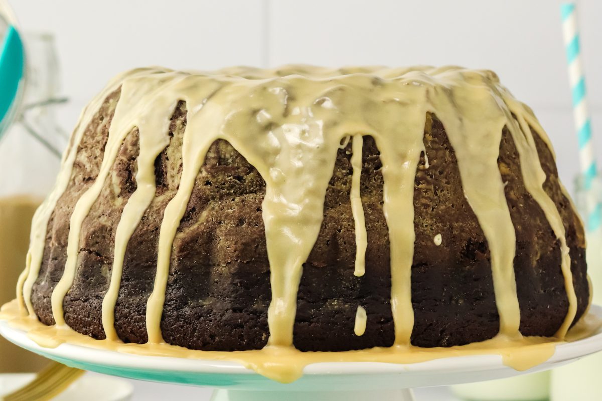 A sideview of a chocolate stout bundt cake drizzled with Irish Cream glaze - Hostess At Heart