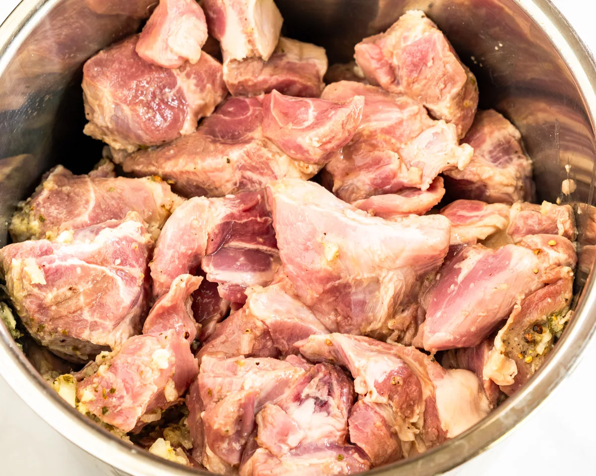 An instant pot filled with chunks of pork in a mojo marinade - Hostess At Heart