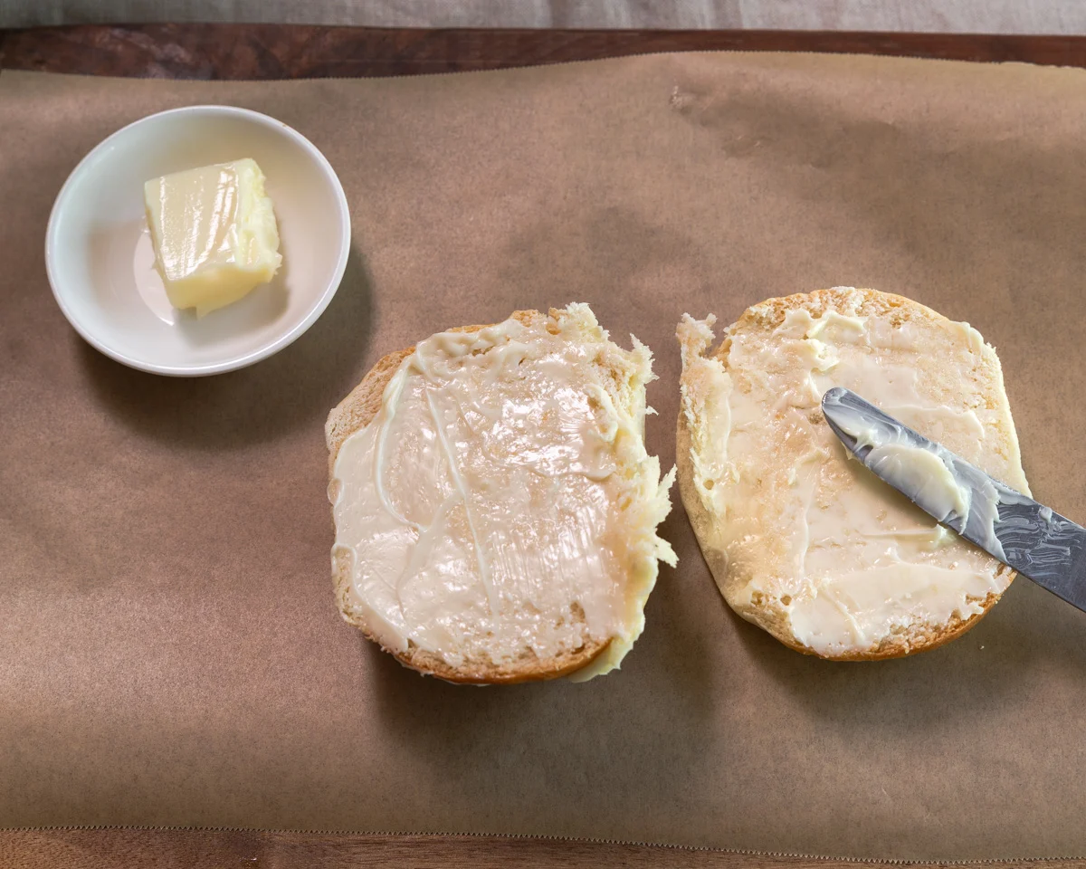 A break roll sliced in half and slathered with butter - Hostess At Heart