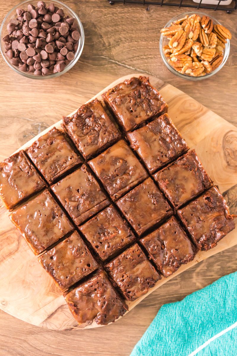 Top down view of sliced caramel topped brownies on a cutting board. Hostess At Heart