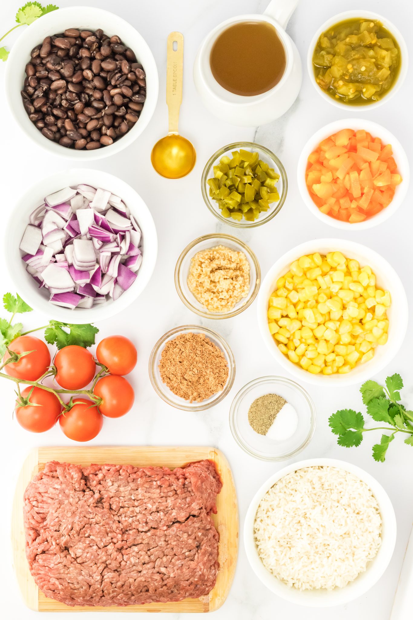 Ingredients: beans, chicken broth, oil, pickled peppers, onion, chilis, red pepper, garlic, tomatoes, corn, seasoning, salt and pepper, ground beef, and rice.