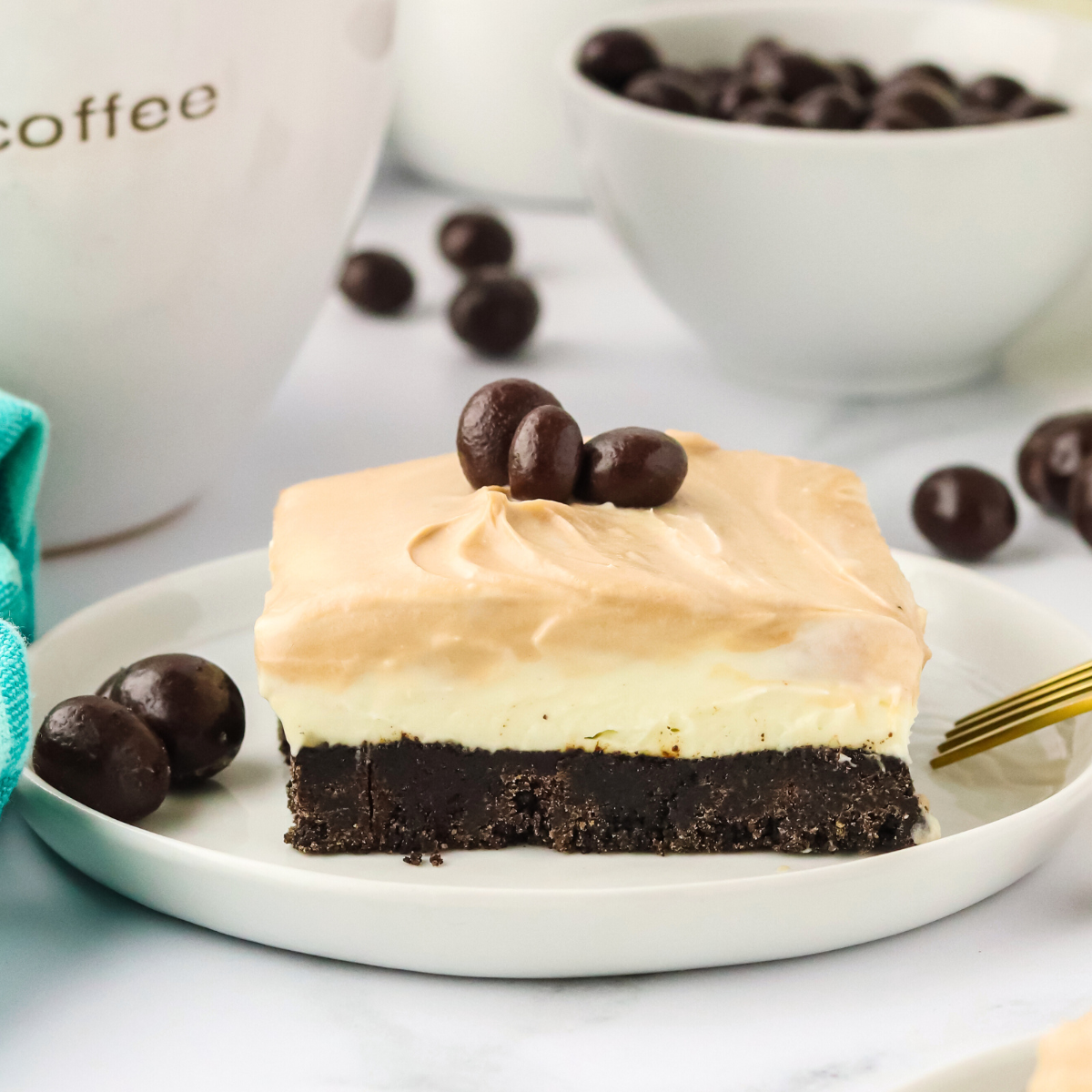 Sidview of a chocolate cappuccino bar showing the Oreo crust layer topped with the cream cheese filling and a cappuccino topping swirled together - Hostess At Heart