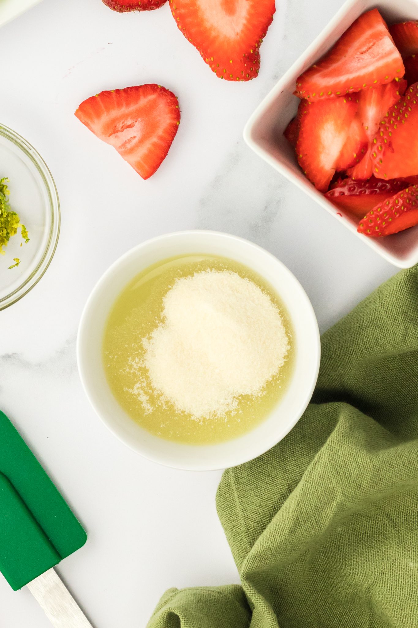 top down view of gelatin and lime juice in a bowl, blooming.