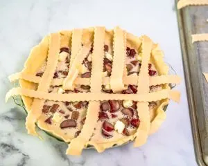 Strips of pie crust crossed over and under to make a lattice crust for a rubarb custard pie - Hostess At Heart