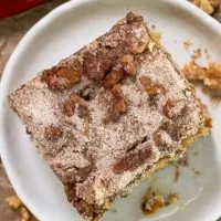 Top down view of a slice of cake topped with a crunchy sugar walnut topping - Hostess At Heart