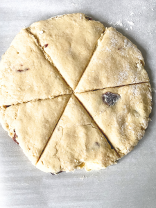 A circle of cherry scones dough cut into 6 wedges before baking - Hostess At Heart