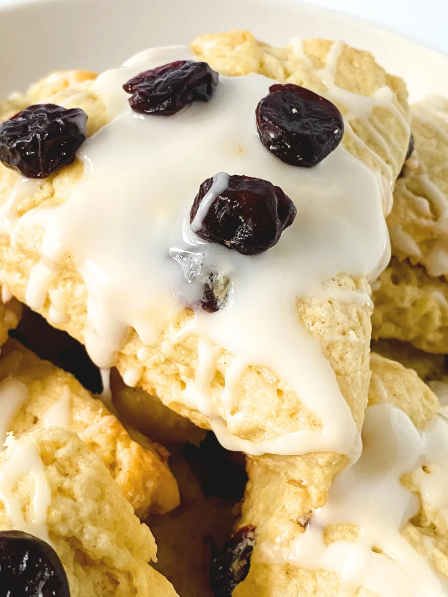 Baked scones, glazed, with cherries on top, close-up. Hostess At Heart