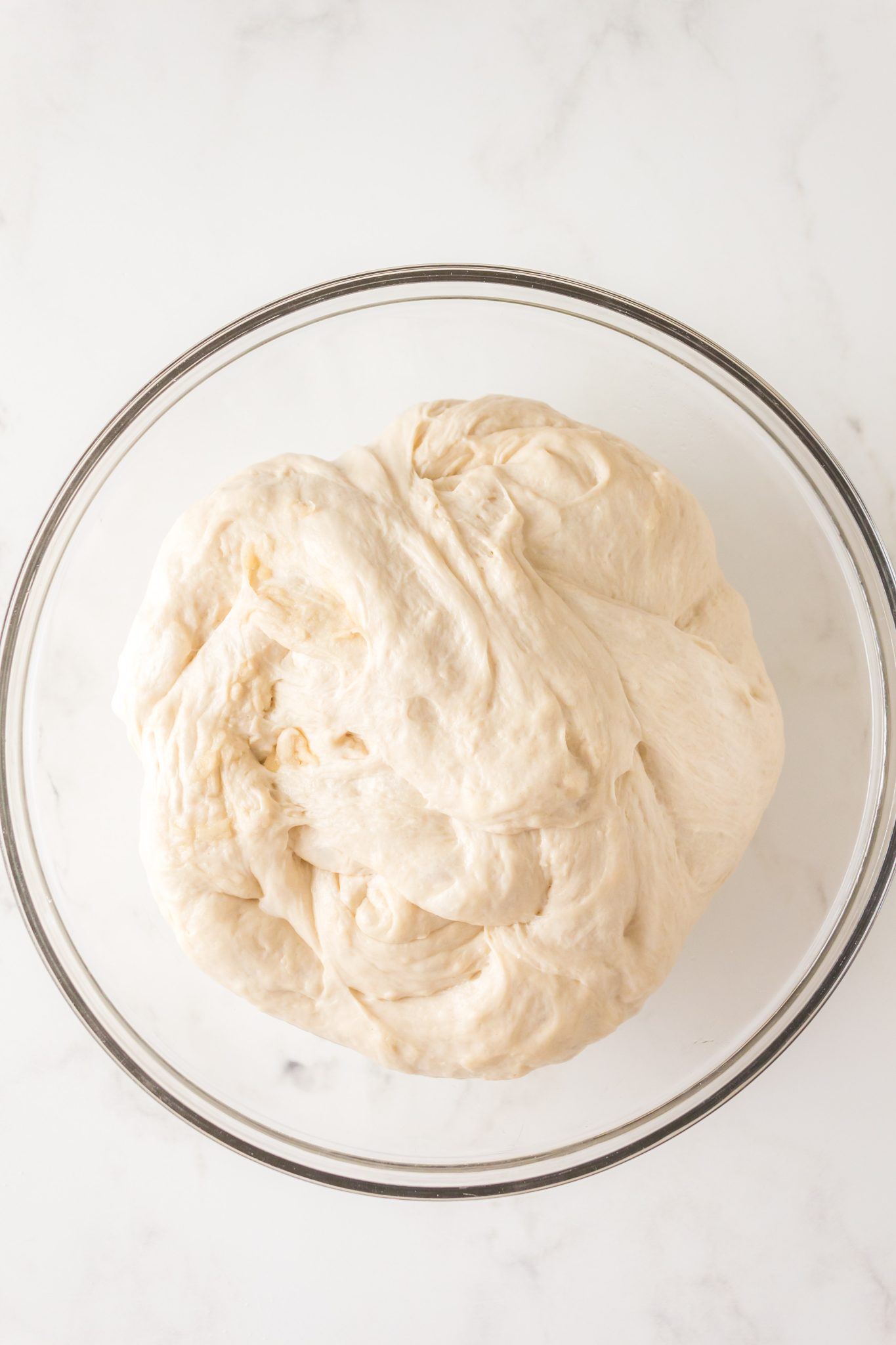 A bowl of soft sourdough starter pizza crust dough - Hostess At Heart