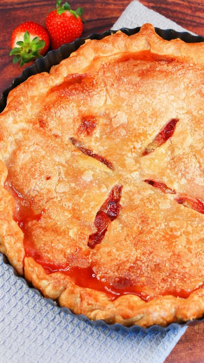 Top down view of a Rhubarb strawberry pie with the juices pooling along the edge - Hostess At Heart