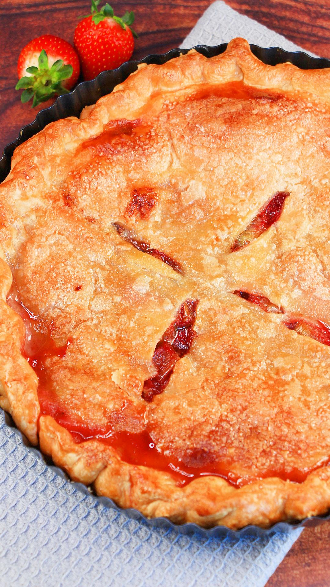 Top down view of a Rhubarb strawberry pie with the juices pooling along the edge - Hostess At Heart