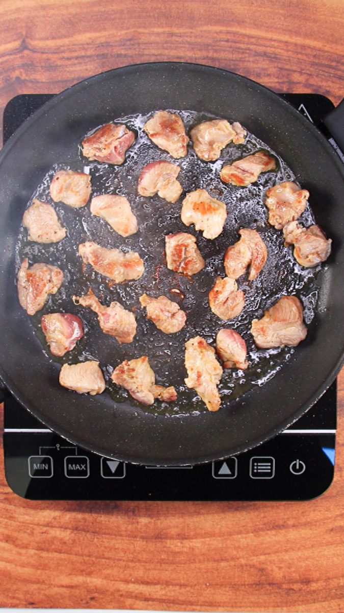 A skillet containing brown chunks of pork - Hostess At Heart