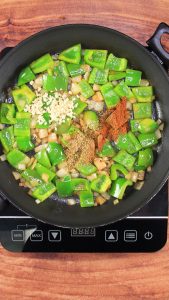 Spices and minced garlic added to a skillet of sauted onion and poblano peppers - Hostess At Heart