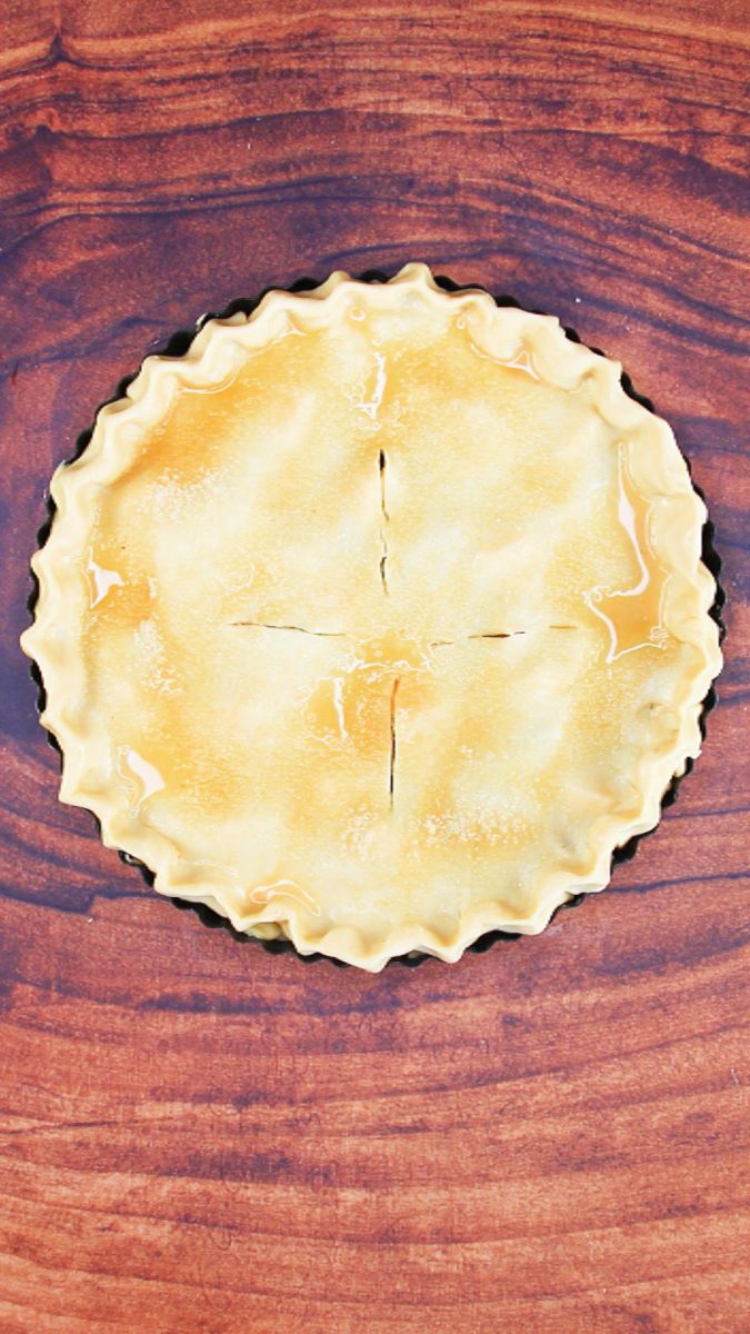 Top down view of a two crust pie washed in egg wash and sprinkled with coarse sugar - Hostess At Heart