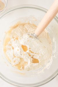 Mixing bowl filled with sourdough starter water and flour - Hostess At Heart