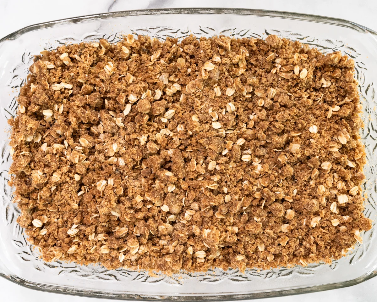 Top down view of a pan of baked rhubarb crisp with oat crumble topping - Hostess At Heart