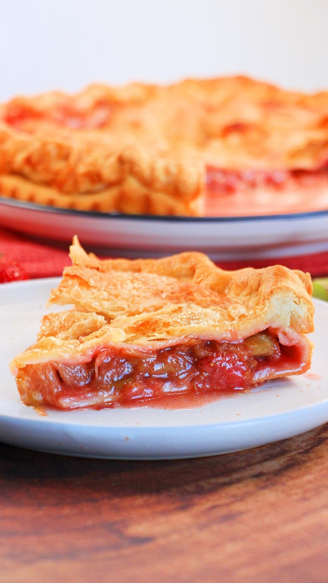 A side view of a slice of strawberries and rhubarb pie on a plate - Hostess At Heart