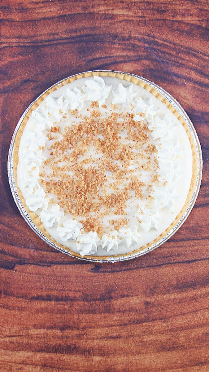 A cream pie topped with crushed pecans and whipped cream stars - Hostess At Heart