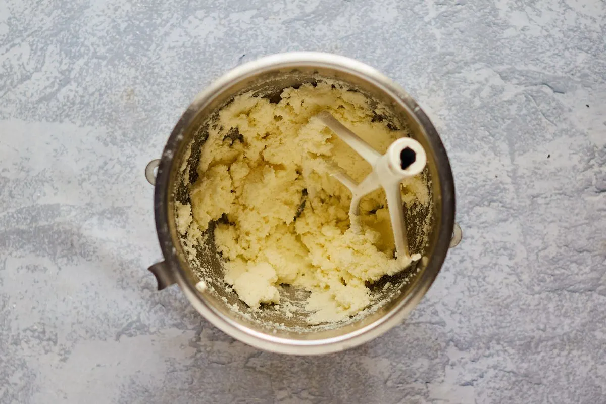 A mixing bowl filled with creamed butter and sugar