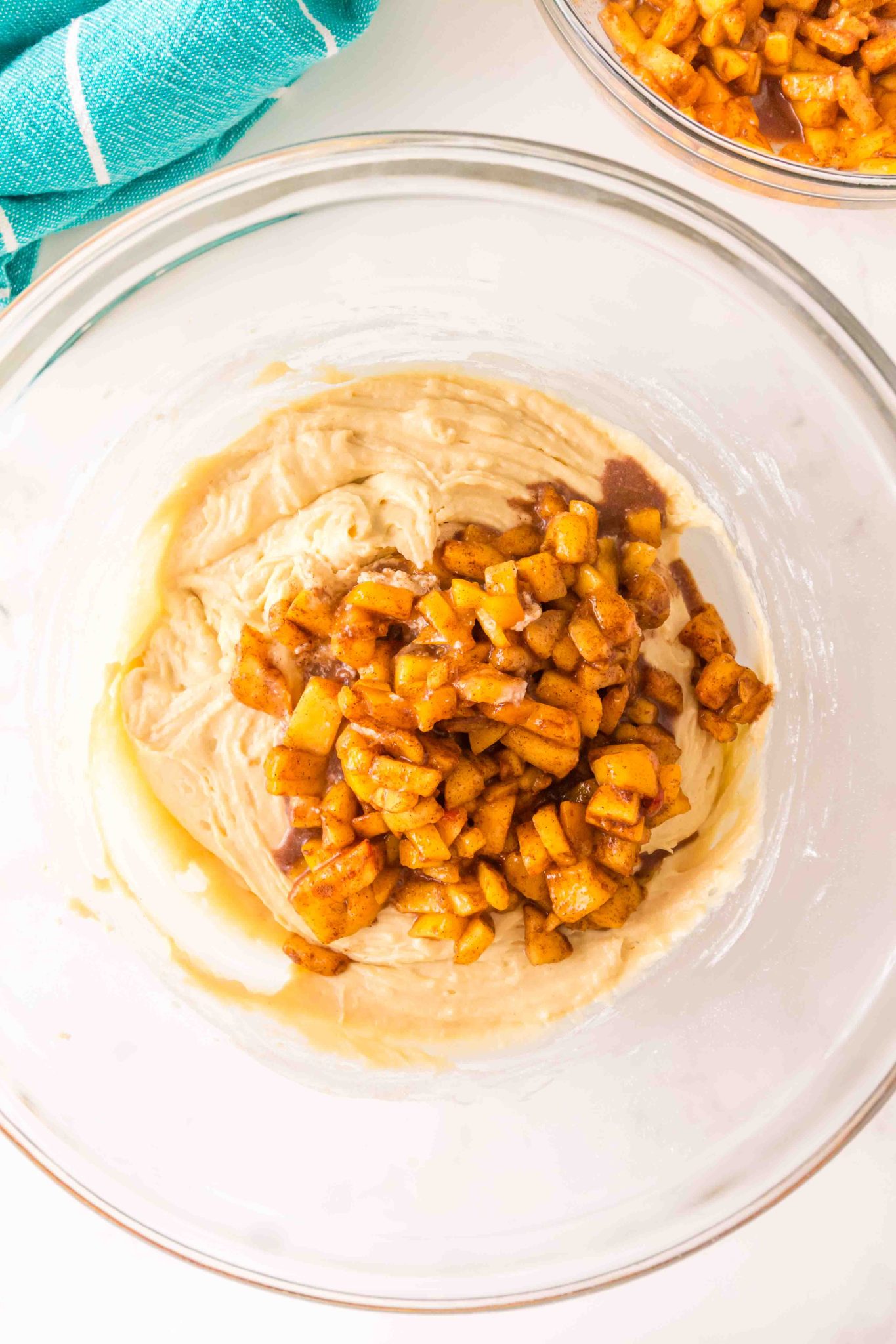 Spiced chopped peaches in a bowl containing batter - Hostess At Heart