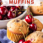 An image for Pinterest of Golden Brown Cherry Muffins in a bowl surrounded by fresh cherries - Hostess At Heart