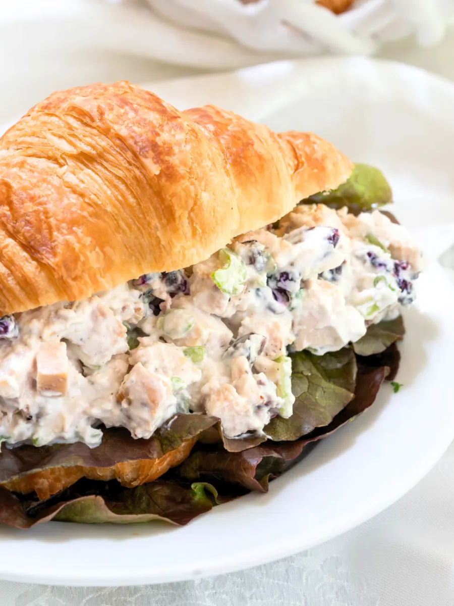 A split croissant roll filled with chicken salad made with yogurt - Hostess At Heart