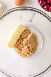 A stick of butter in a bowl with brown sugar and white sugar - Hostess At Heart