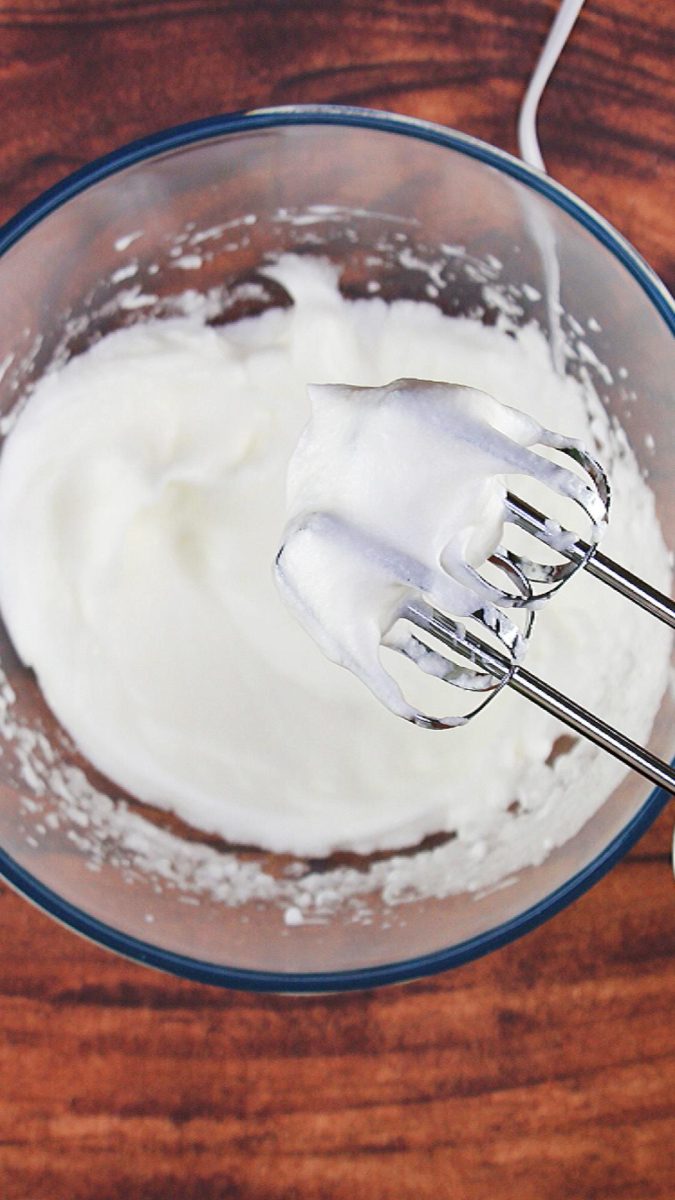 A bowl of egg whites whipped into soft peaks - Hostess At Heart