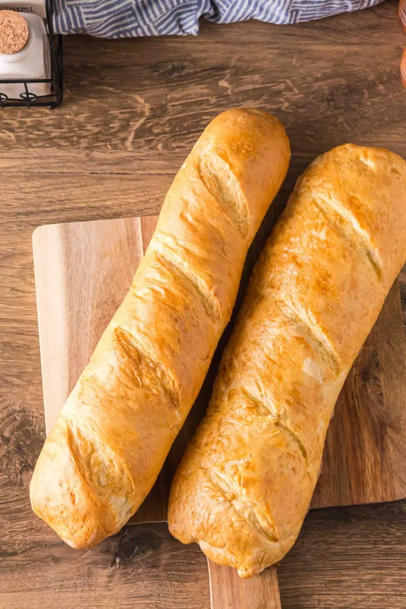 Two baked baguettes sitting together on a cutting board - Hostess At Heart