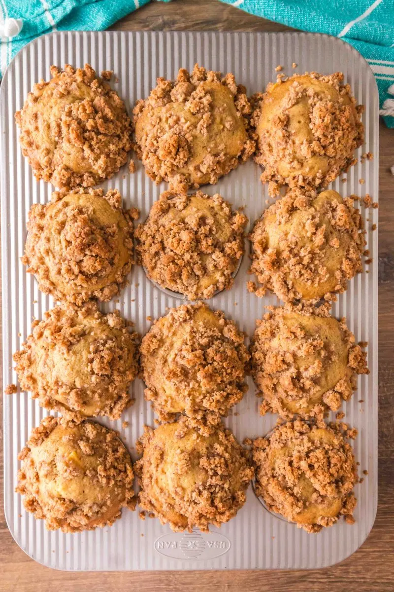 Top down view of baked muffins topped with crumble in a muffin pan - Hostess At Heart
