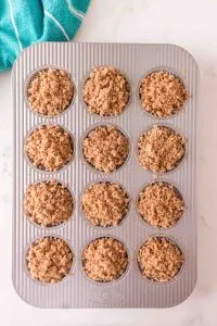 A muffin pan filled with streusel topped muffins - Hostess At Heart