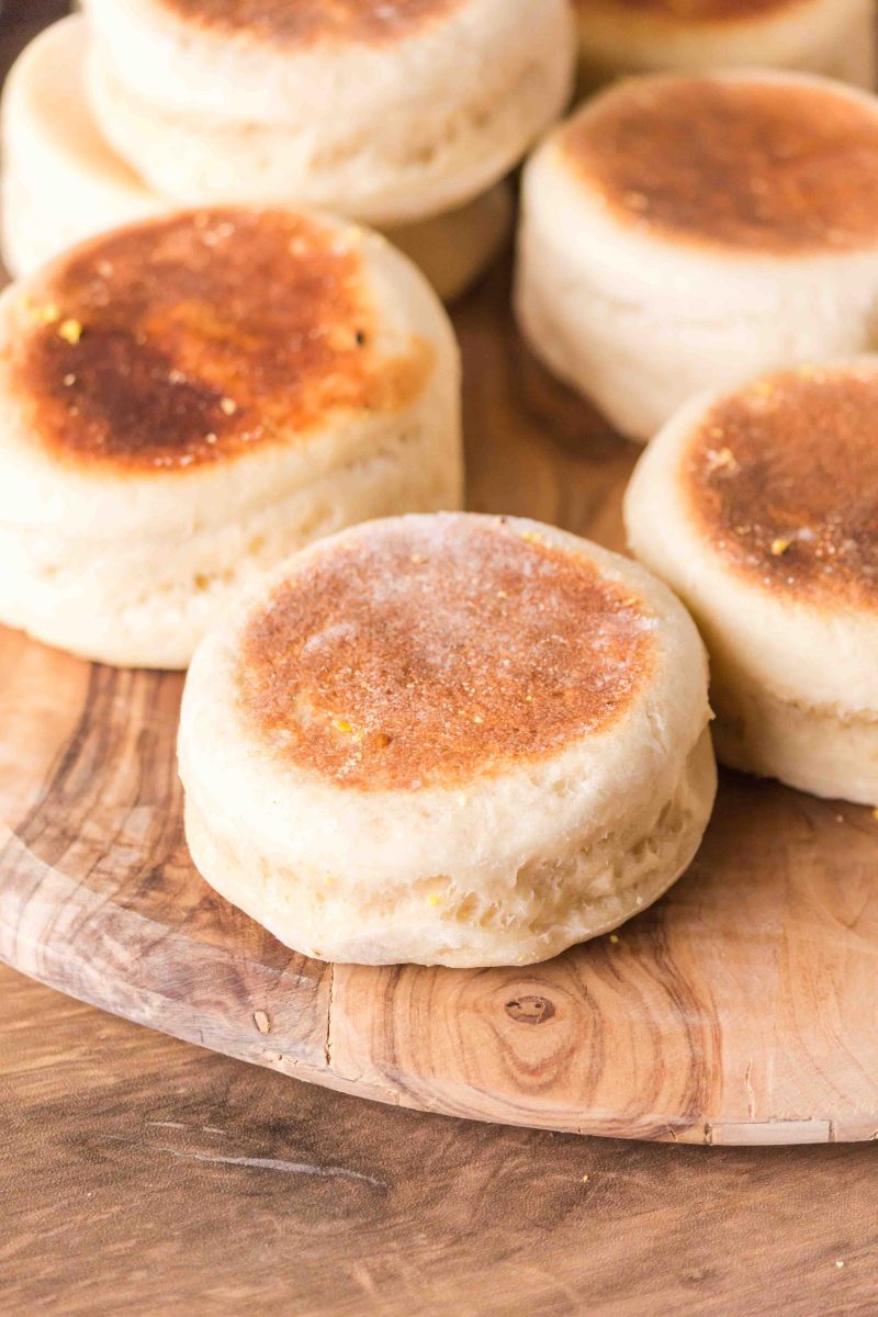 Tableview of baked sourdough english muffins recipes sitting on a cutting board - Hostess At Heart