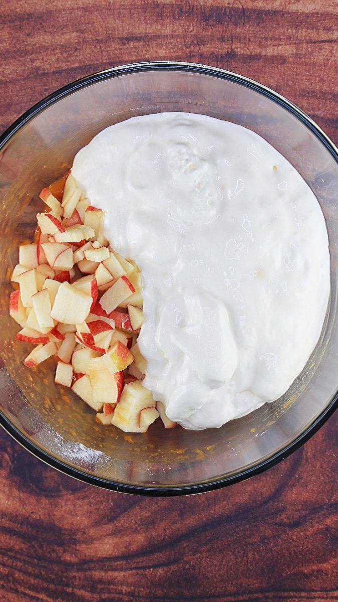 Top down view of a bowl filled with diced apples and Cool Whip topping - Hostess At Heart