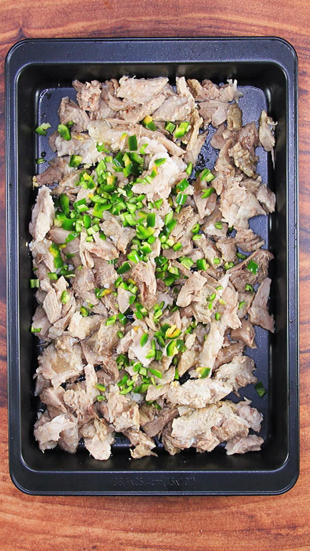 A sheet pan filled with pulled pork and diced green jalapenos - Hostess At Heart