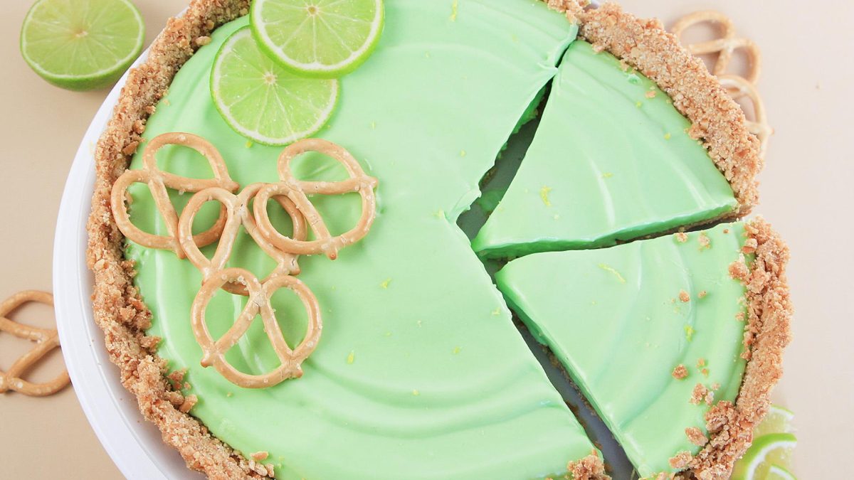 Margarita Pie on a pie plate, top-down view, decorated with lime slices and pretzels.