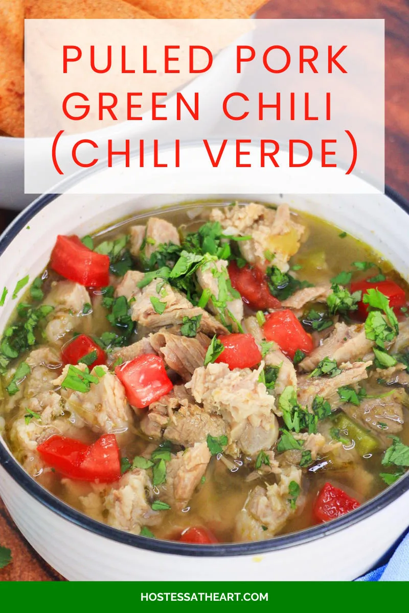 An image for Pinterest of a bowl of Pulled Pork Green Chili Verde garnished with cilantro and freshly chopped tomatoes - Hostess At Heart