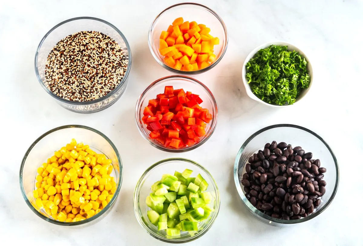 Inredients include quinoa, carrots, red peppers, parsley, corn, black beans, and cucumbers.