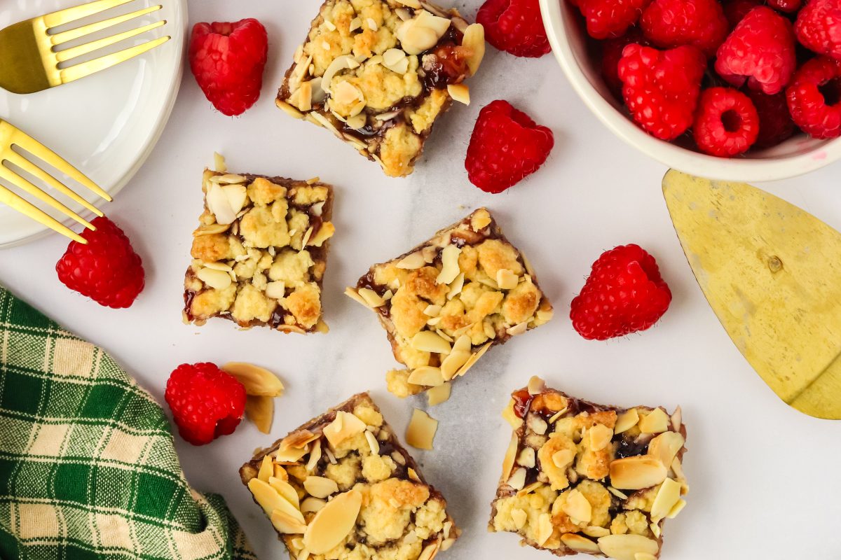Top down view of Dessert Bars made with raspberry jelly over a short bread crust and topped with crumble with almonds - Hostess At Heart