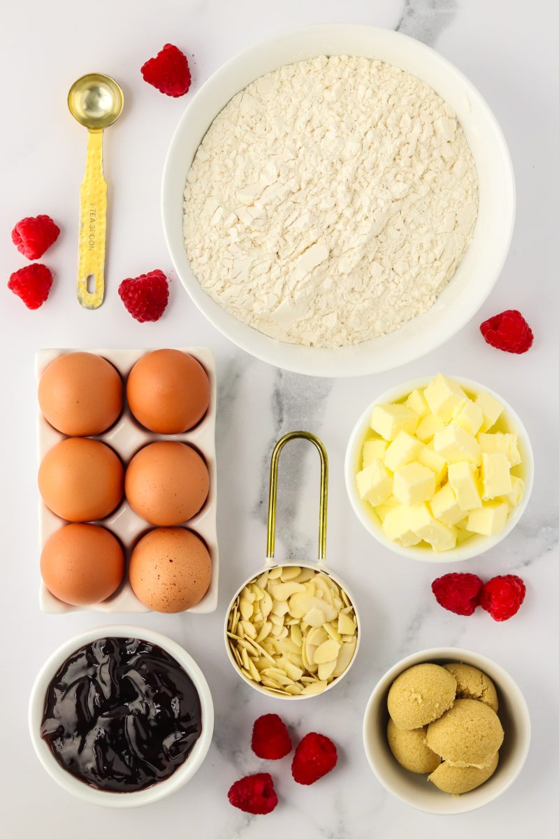 Ingredients used to make raspberry jam bars including brown sugar, raspberry jelly, egg, flour, and butter - Hostess At Heart