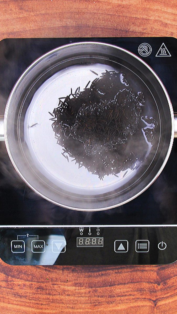 Wild rice sitting in a pan of boiling water - Hostess At Heart