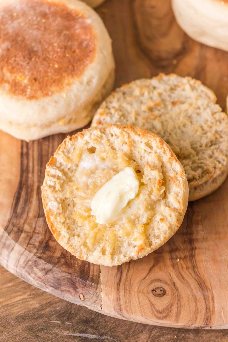 Top down view of a split English Muffin with a pad of melting butter on top - Hostess At Heart
