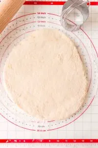 Top down view of dough rolled into a circle on a baking mat - Hostess At Heart