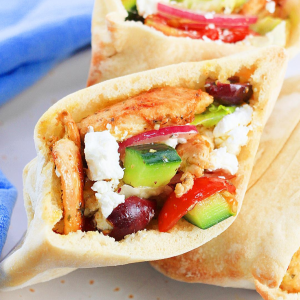 A Gyro Chicken filled pita bread with veggies and olives with feta - Hostess At Heart