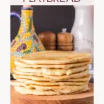 Sideview of homemade flat bread recipe sitting on a cutting board with an oil caraffe in the distance. Hostessatheart.com