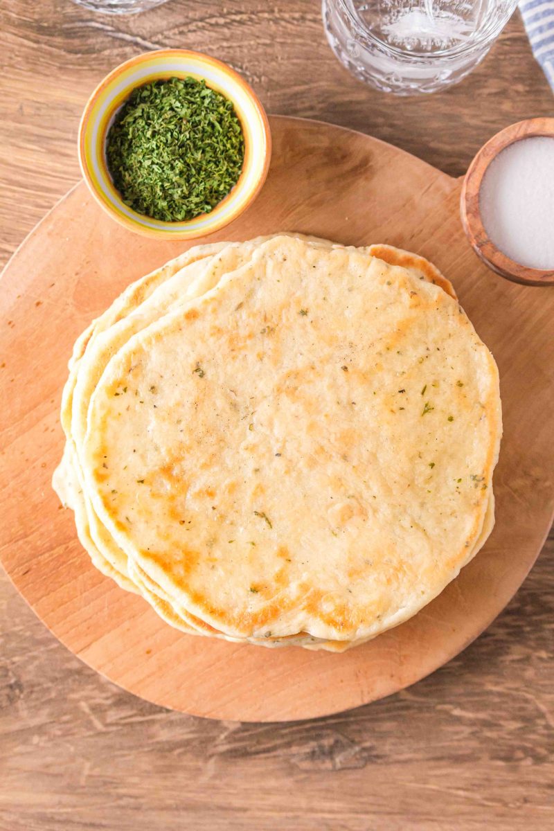 Top down view of a stack of homemade flatbread sitting on a cutting board - Hostess At Heart